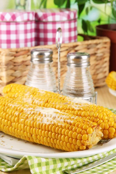 Flavored boiled corn on plate on wooden table on natural background — Stock Photo, Image