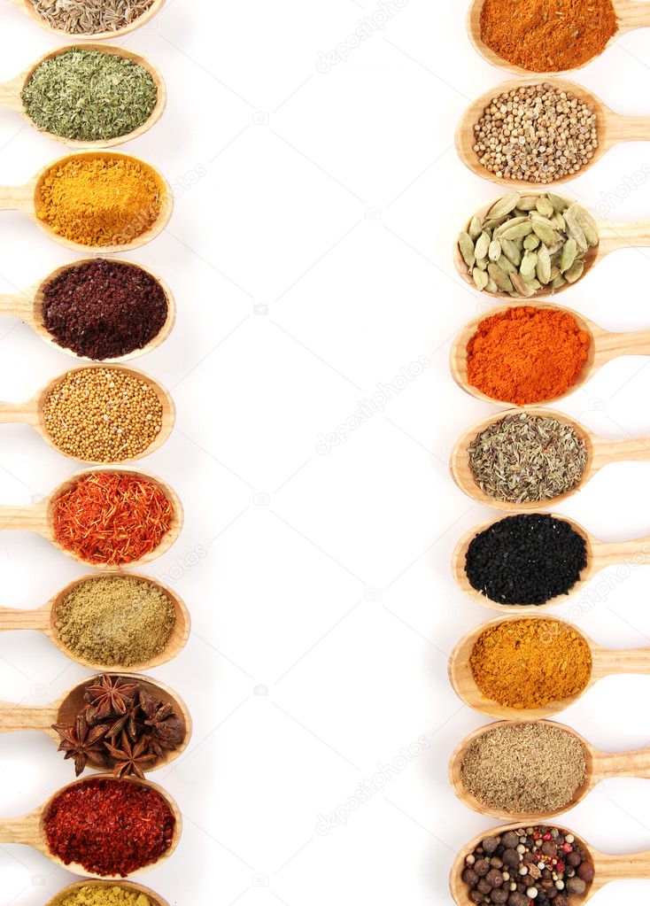 Assortment of spices in wooden spoons, isolated on white