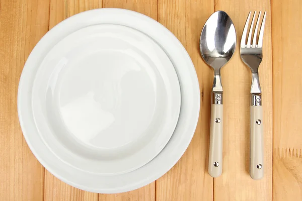 Plate and cutlery on wooden table close-up — Stockfoto