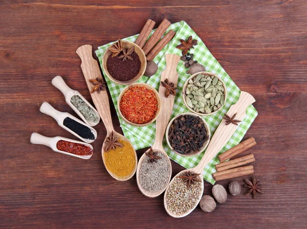 Verschillende kruiden en specerijen op houten ondergrond — Stockfoto