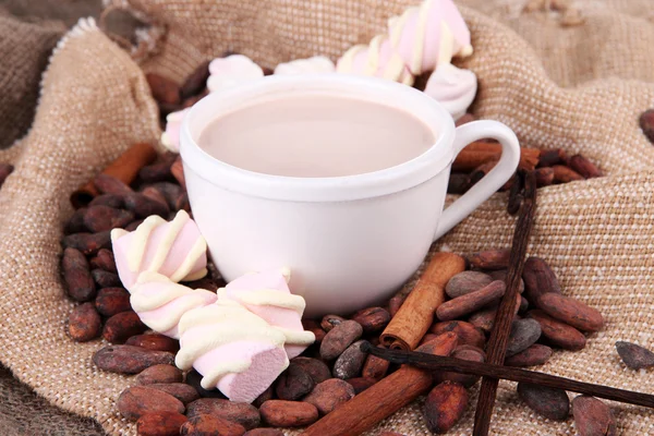 Chocoladedrinks en cacaobonen op rouwgewaad achtergrond — Stockfoto