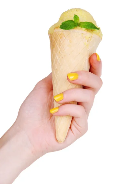 Hand holding yellow ice cream with mint in waffle cone isolated on white — Stock Photo, Image