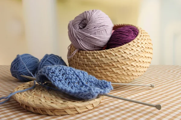 Multicolored clews in wicker basket with needles closeup — Stock Photo, Image