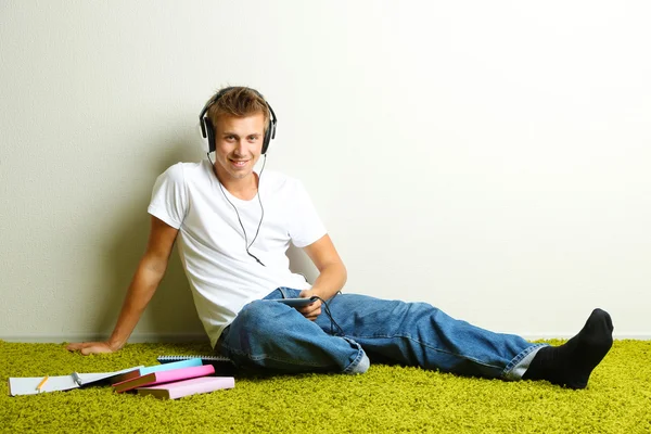 Hombre joven relajándose en la alfombra y escuchando música —  Fotos de Stock