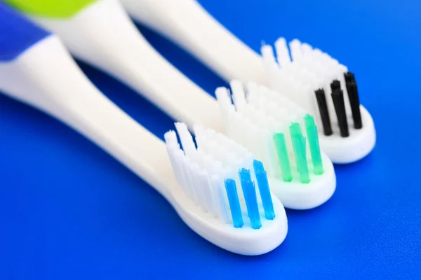 Tooth-brushes on blue background — Stock Photo, Image