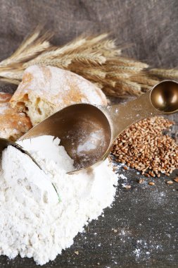 kepekli un üstünde çul zemin üzerine ahşap masa kaşık toz içinde