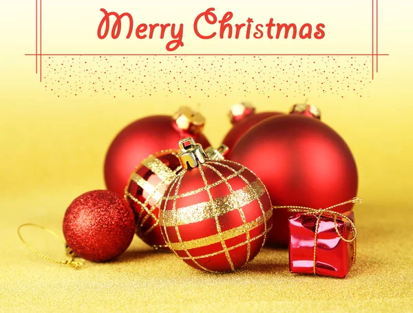 Noel topları ve Sarı zemin üzerine küçük bir hediye — Stok fotoğraf