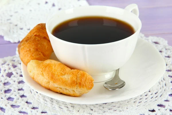 Croissants saborosos e xícara de café na mesa close-up — Fotografia de Stock