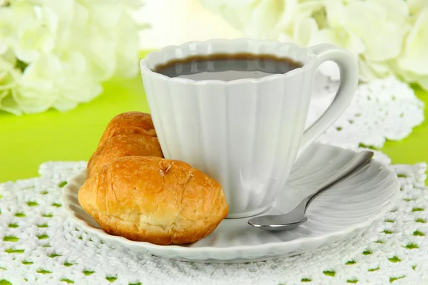 Croissant gustosi e una tazza di caffè in tavola primo piano — Foto Stock