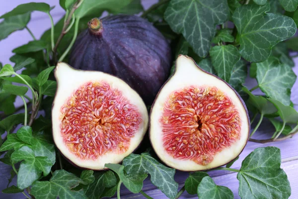 Figues mûres en feuilles sur table en bois close-up — Photo