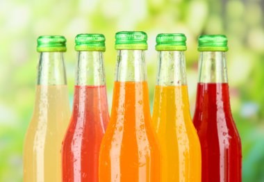 Bottles with tasty drinks on bright background clipart