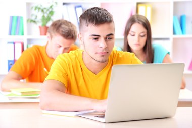 Kütüphanede oturan genç öğrenci grubu