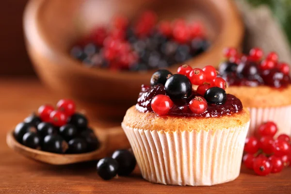 Tasty muffins with berries on wooden table — Stock Photo, Image