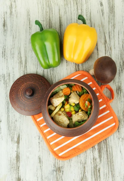 鍋つかみは、木製の背景上で肉と野菜のキャセロール — ストック写真