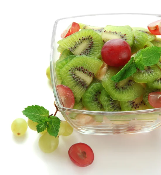 Smakelijke fruitsalade in glazen kom, geïsoleerd op wit — Stockfoto