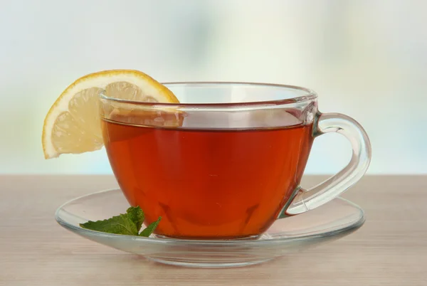 Kopje thee met citroen op tafel op lichte ondergrond — Stockfoto