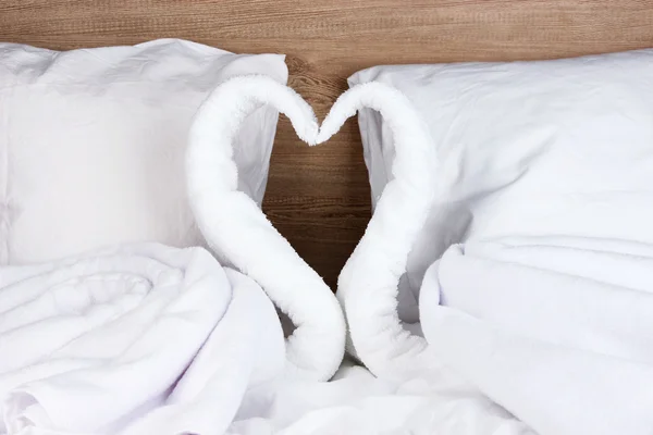 木製の背景上のベッドの上のタオルから作られた白鳥 — ストック写真