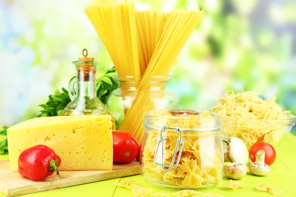 Pasta met olie, kaas en groenten op houten tafel op natuurlijke achtergrond — Stockfoto