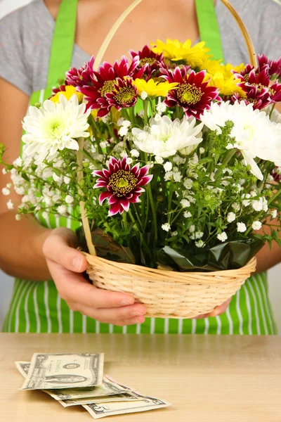 Fiorista rende mazzo di fiori in cesto di vimini — Foto Stock