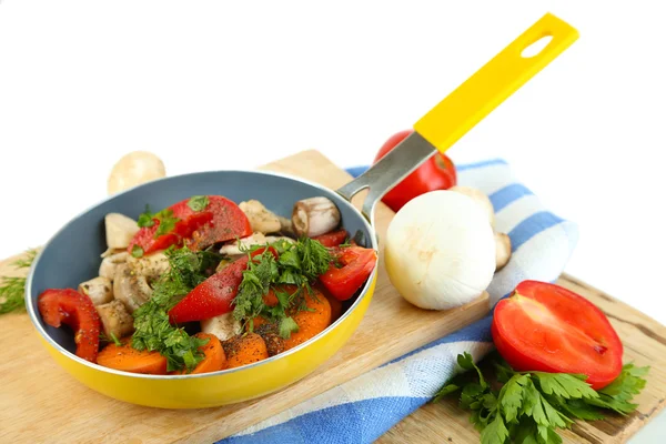 Verduras frescas en rodajas en sartén sobre tabla de madera aislada sobre blanco — Foto de Stock