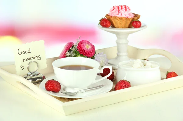 Xícara de chá com bolos na bandeja de madeira na mesa no quarto — Fotografia de Stock