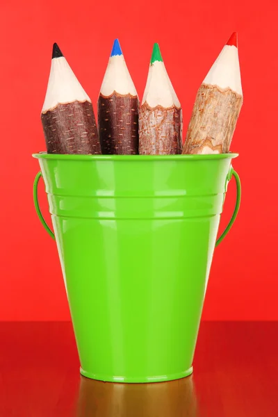 Secchio di colore con matite multicolore, su sfondo colore — Foto Stock