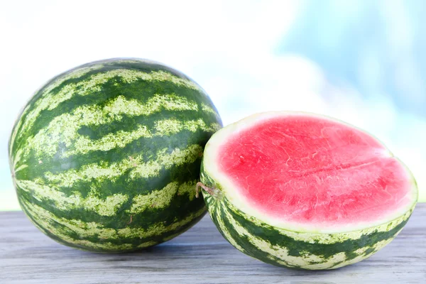 Reife Wassermelonen auf Holztisch auf Naturhintergrund — Stockfoto