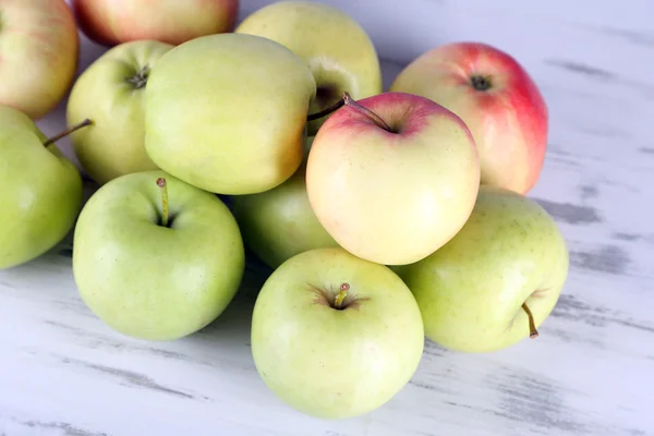 Šťavnatá jablka na dřevěný stůl — Stock fotografie