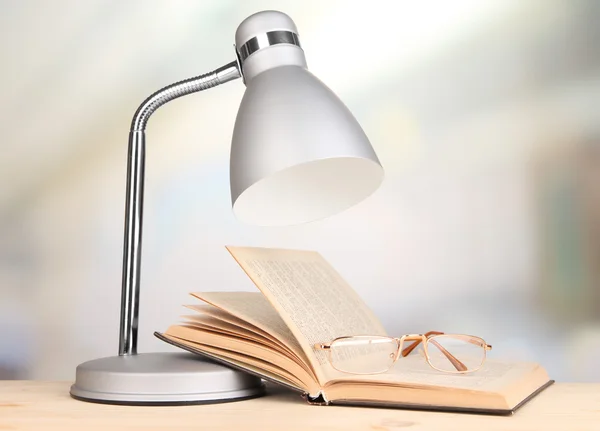 Lampada da tavolo e libro aperto in camera — Foto Stock