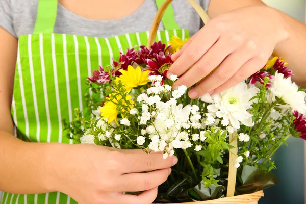 Fiorista rende mazzo di fiori in cesto di vimini — Foto Stock