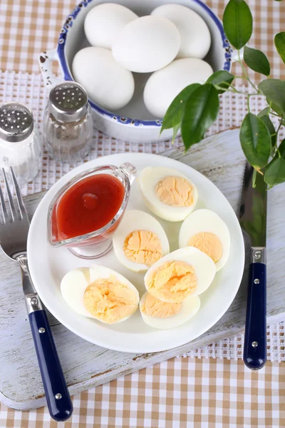 Huevos cocidos en plato sobre tabla de madera sobre mantel —  Fotos de Stock