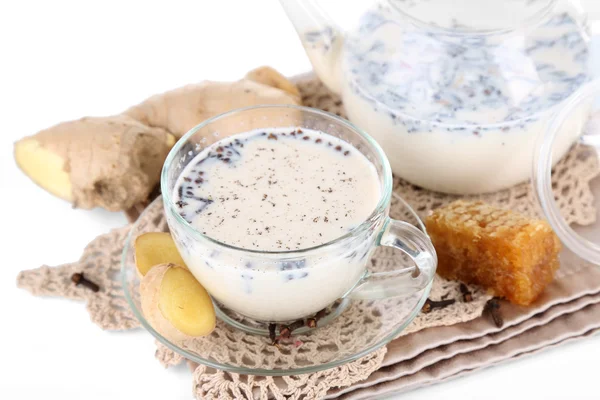 Tetera y taza de té con leche y especias en servilleta aislada en blanco — Foto de Stock