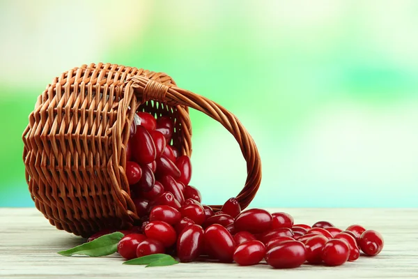 Fresh cornel berries in basket on wooden table — Stock Photo, Image