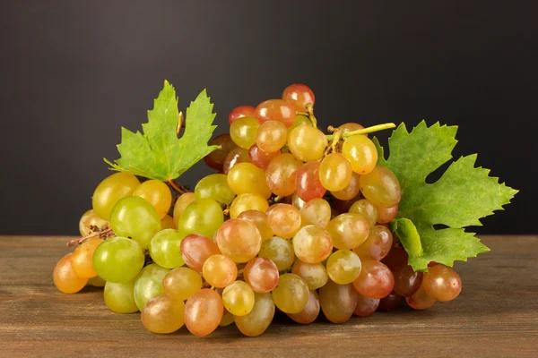 Dojrzałe słodkie winogrona na drewnianym stole, na szarym tle — Zdjęcie stockowe
