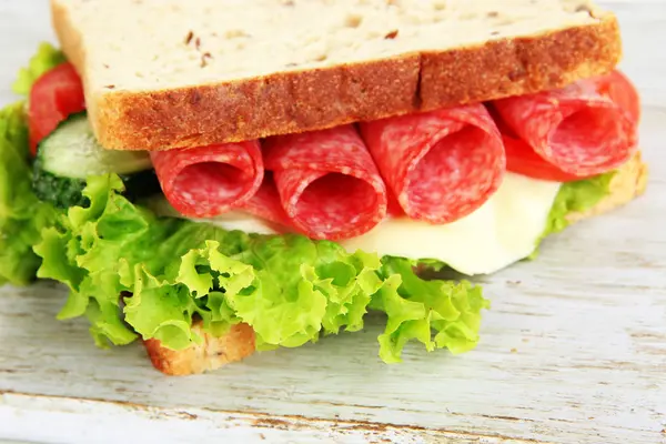 Chutný sendvič s salám klobása a zeleniny na prkénku, close-up — Stock fotografie