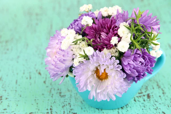 Hermoso ramo de flores brillantes en jarrón de color, sobre fondo brillante —  Fotos de Stock