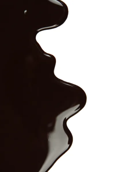 Melted chocolate dripping on white background — Stock Photo, Image