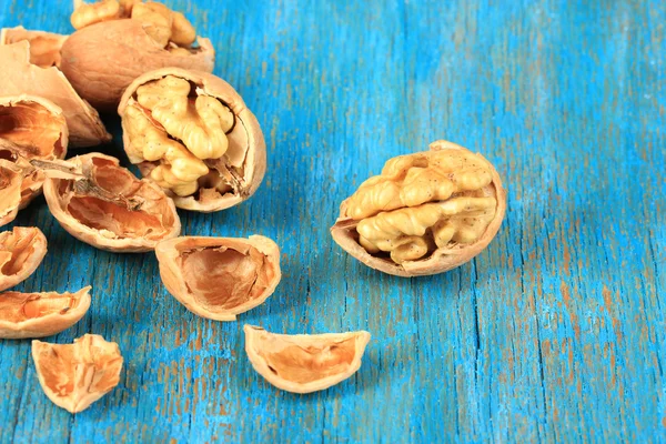 Broken walnuts on wooden table close-up — Stock Photo, Image