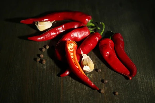 Red hot chili peppers and garlic, on wooden background — Stock Photo, Image