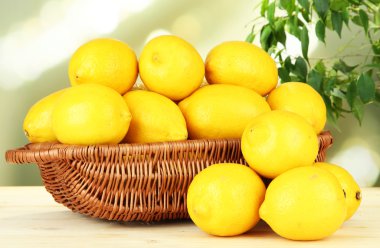 parlak zemin üzerinde tablo hasır sepet içinde olgunlaşmış limon