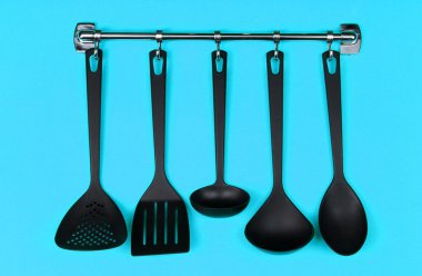 Gümüş kanca, mavi arka plan üzerinde siyah mutfak gereçleri