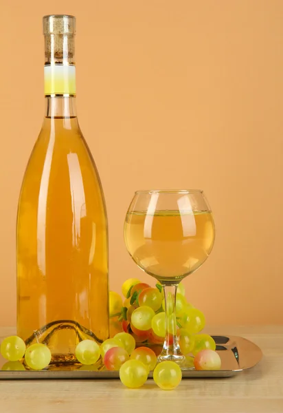 Vinho branco em vidro com garrafa em salver no fundo bege — Fotografia de Stock