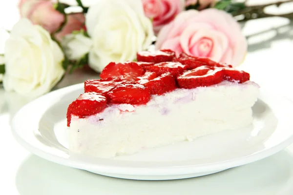 Cheesecake med färska jordgubbar på vit platta närbild — Stockfoto