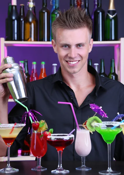 Portrait of handsome barman with different cocktails cocktail, at bar — Stock Photo, Image