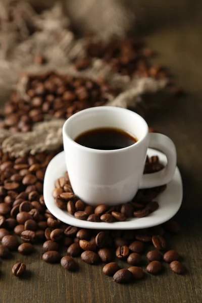 Tazza di caffè e chicchi di caffè su sfondo di legno — Foto Stock