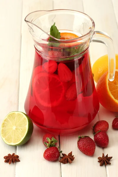 Sangria in jar with fruits, on white wooden table — Stock Photo, Image