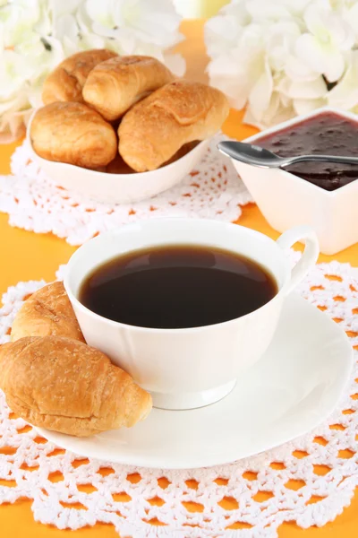 Leckere Croissants und eine Tasse Kaffee auf dem Tisch aus nächster Nähe — Stockfoto