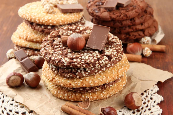 Biscotti fatti in casa con semi di sesamo, cioccolato, su tovagliolo, su sfondo di legno — Foto Stock