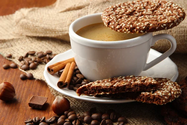 Xícara de café saboroso com biscoitos saborosos, em fundo de madeira — Fotografia de Stock