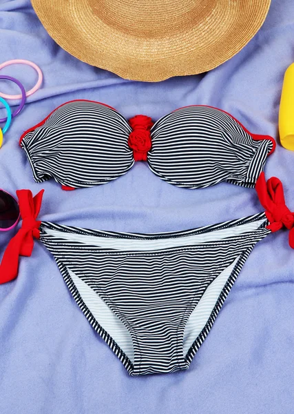 Badeanzug und Strandartikel auf lila Hintergrund — Stockfoto